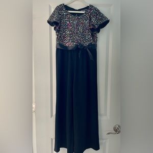 Rainbow color sequence top with black pants bottom, one piece.